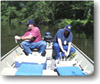 picture of two men in boat collecting samples